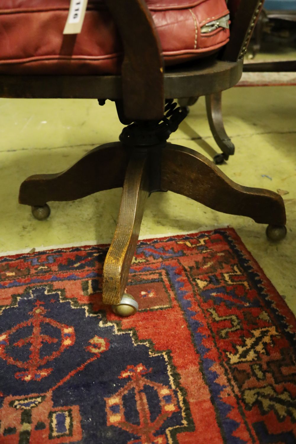 A 1920s oak swivel desk chair, the back and seat cushion covered in red hide, width 63cm, depth 50cm, height 94cm